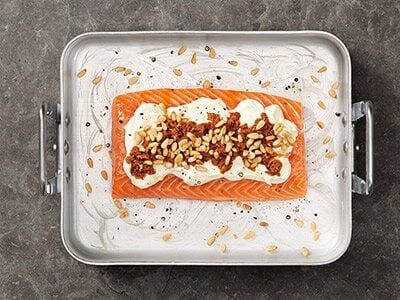 Lax i ugn med pesto, crème fraîche och pinjenötter